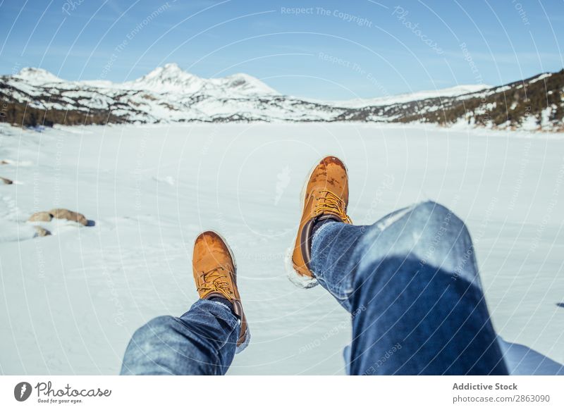 Männerbeine in Winterstiefeln auf Schnee in der Nähe von Bergen Mann Stiefel Berge u. Gebirge cerdanya Frankreich Beine Jeanshose Schönes Wetter Hügel sitzen