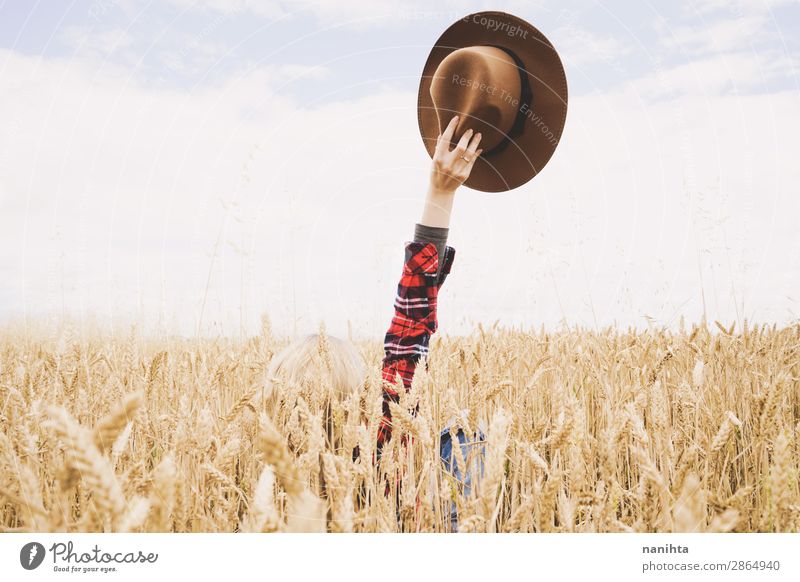 Hand hält einen Cowboyhut über einem Weizenfeld. Bioprodukte Lifestyle Glück schön Wellness Leben Zufriedenheit Erholung Freiheit Sommer Landwirtschaft