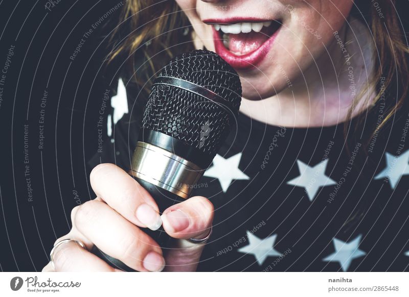 Junge Frau singt ein Lied mit einem Mikrofon. Lifestyle Stil Freude Gesicht Leben Freizeit & Hobby Technik & Technologie Unterhaltungselektronik Mensch feminin