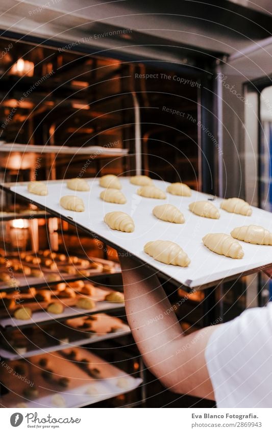 Frau, die ein Regal mit Croissants in einer Bäckerei hält. Brot Glück Küche Restaurant Schule Arbeit & Erwerbstätigkeit Beruf Fotokamera feminin Erwachsene Hand