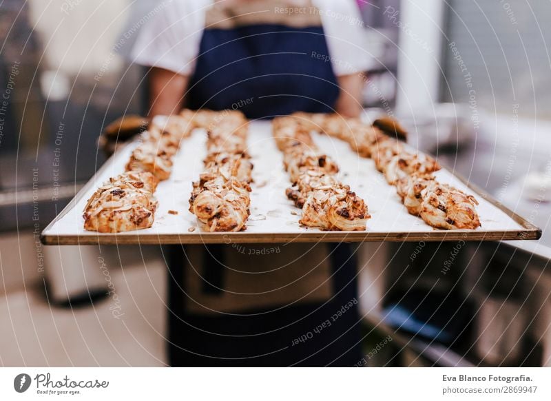 Frau hält ein Regal mit Süßigkeiten in der Bäckerei. Brot Glück Küche Restaurant Schule Arbeit & Erwerbstätigkeit Beruf Fotokamera feminin Erwachsene 1 Mensch