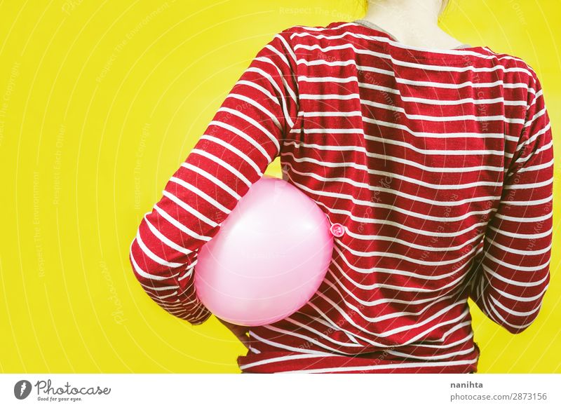 Rückansicht eines Mädchens, das einen Ballon hält. Stil Design Feste & Feiern Geburtstag Kind Frau Erwachsene Kindheit Kunst Hemd Luftballon Streifen