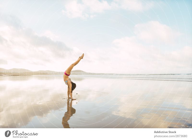 Frau beim Handstand am Meer Badebekleidung Sand nass Barfuß üben dünn Fitness Training Sport Wasser Dame Bikini Jugendliche Himmel Yoga Pose Strand