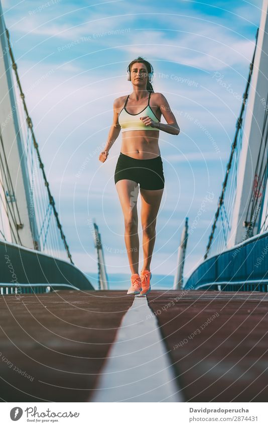 Junge, fitte, blonde Frau, die auf der Brücke läuft. rennen üben Fitness ausarbeiten Lifestyle Bewegung Aktion Joggen vertikal sportlich Gesundheit ausarbeitend