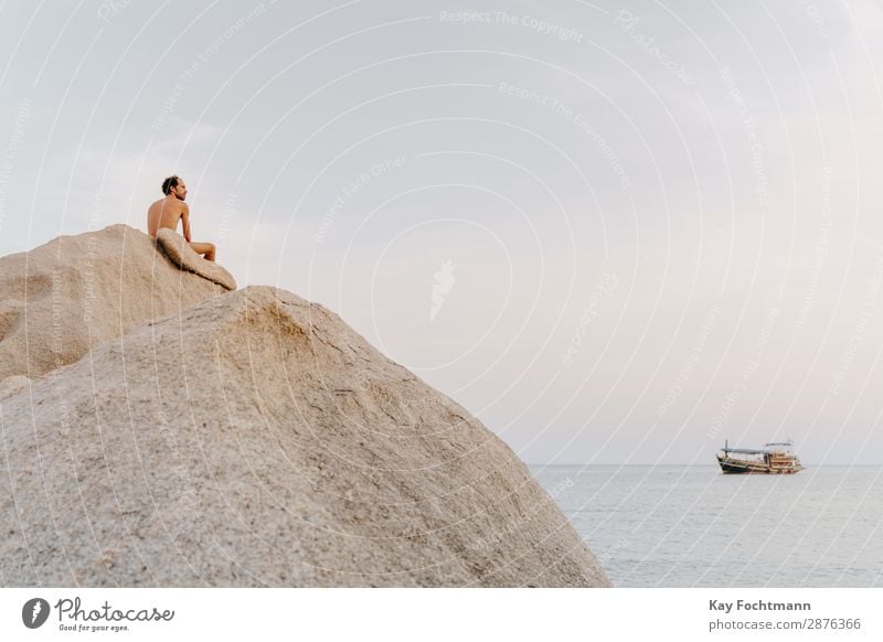 Mann mit freiem Oberkörper sitzt auf großem Fels am Meer Glück Gesundheit Fitness Wellness Leben harmonisch Wohlgefühl Erholung ruhig Meditation