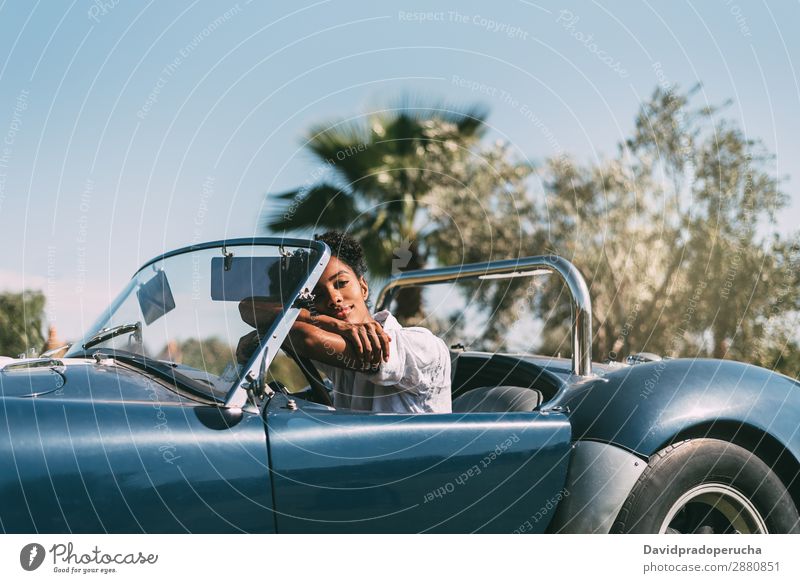 Schwarze Frau fährt ein Oldtimer-Cabriolet. PKW fahren urwüchsig Glück Straße schwarz Reichtum Wegsehen Lächeln Profil klassisch 60's schön Verkehr altehrwürdig