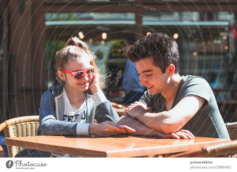 Junge Leute, die im Café sitzen, reden und Mobiltelefone benutzen. Lifestyle Freude Glück Sommer Tisch Restaurant Telefon PDA Technik & Technologie Frau