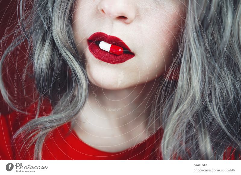 Nahaufnahme der Lippen junger Frauen, die eine Pille halten. Design Haut Gesicht Lippenstift Gesundheit Gesundheitswesen Behandlung Rauschmittel Medikament