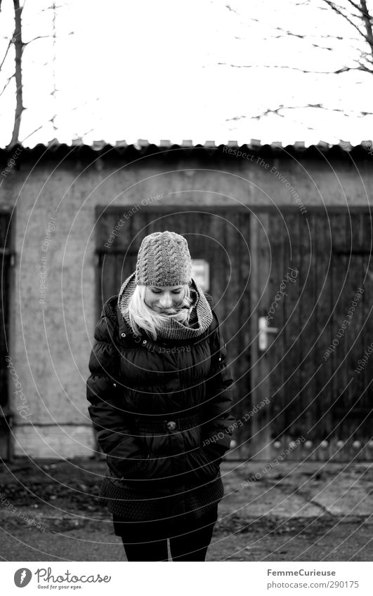 An der frischen Winterluft. feminin Junge Frau Jugendliche Erwachsene 1 Mensch 18-30 Jahre Natur Garten Hof Freude Verschmitzt Mantel Daunen Mütze Schal