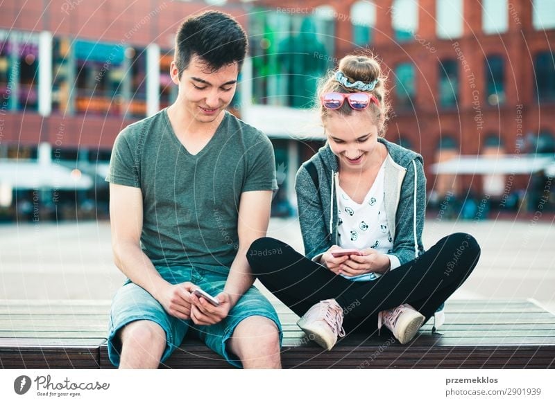 Teenager Mädchen und Jungen, die Spaß zusammen mit Smartphones haben. Lifestyle Sommer sprechen Telefon Handy PDA Technik & Technologie Frau Erwachsene Mann