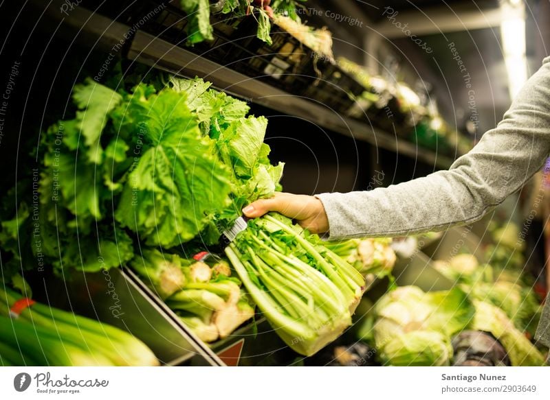 Nahaufnahme einer Frau, die im Supermarkt einen Salat nimmt. kaufen Hand nehmen Lebensmittel Markt benutzend Mensch Jugendliche Lächeln Karre Lifestyle Kunde