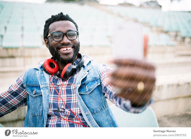 Ein amerikanischer Mann, der ein Handy auf der Straße benutzt. Telefon Stadt Afrikanisch schwarz Amerikaner Mobile Jugendliche lachen PDA Technik & Technologie