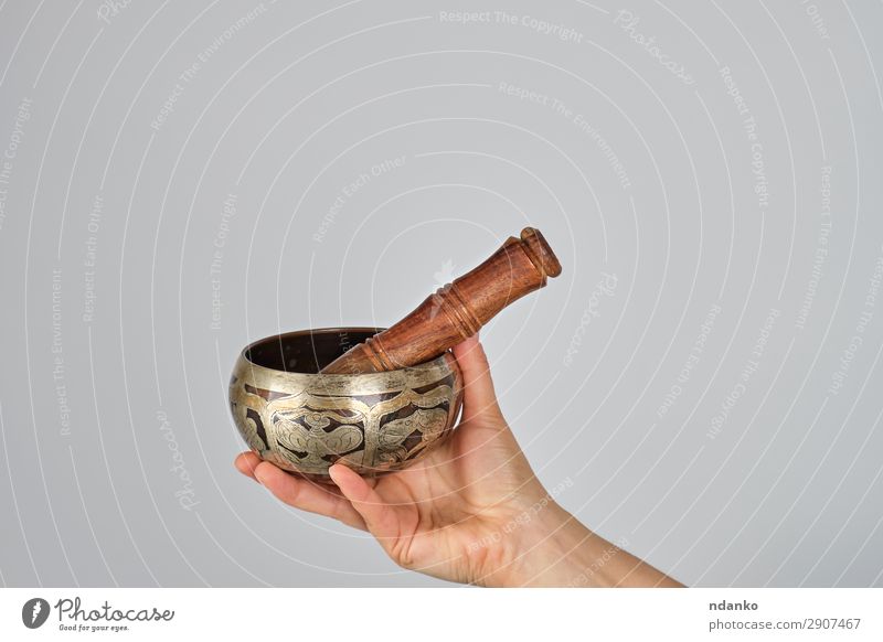 Kupferklangschale und Holzstab in Frauenhand Schalen & Schüsseln Lifestyle Körper Erholung Meditation Musik Yoga Erwachsene Hand Metall weiß Frieden