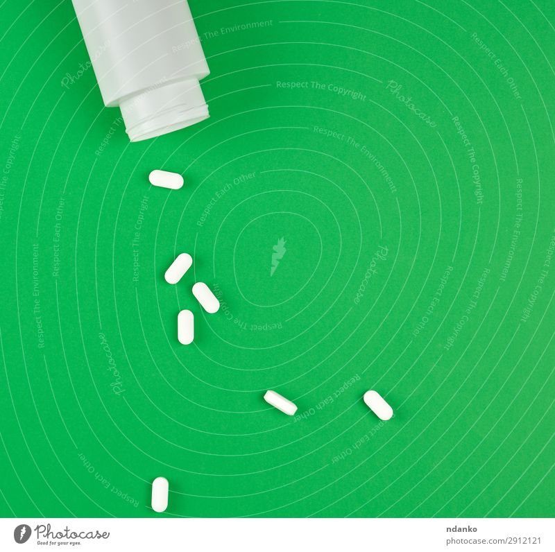 weiße Plastikdose und verstreute ovale Pillen. Gesundheit Gesundheitswesen Krankheit Medikament oben grün Idee Antibiotikum Kasten Pflege Kur Glas legen Medizin