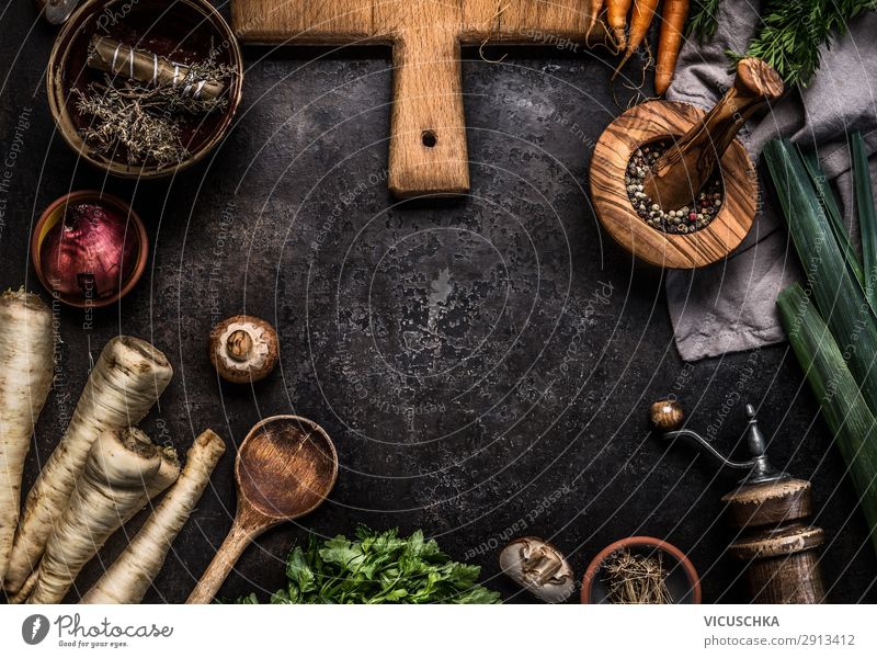Rustic food background with root vegetables, herbs,spices ,leek and champignon mushrooms on dark rustic table with kitchen utensils, top view. Copy space