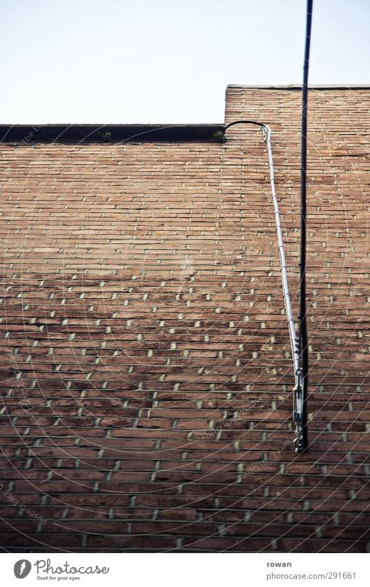 mauerkabel Bauwerk Mauer Wand Fassade rot Backstein ziegelrot Backsteinwand Kabel Elektrizität Verbindung Anschluss Telefonkabel vertikal Linie aufwärts