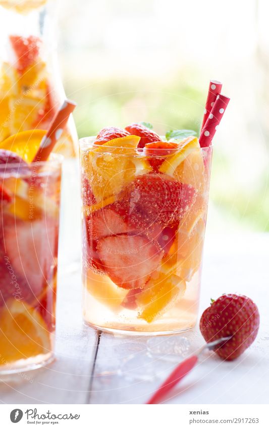 Sommerliches Erfrischungsgetränk mit Orange und Erdbeeren Frucht Bioprodukte Vegetarische Ernährung Getränk Trinkwasser Flasche Glas Trinkhalm Gabel Karaffen