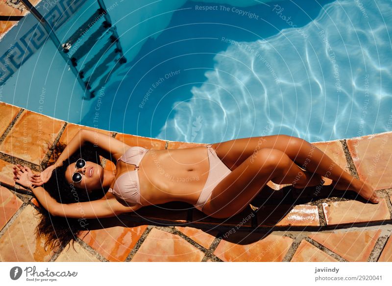 Entspannte Frau beim Sonnenbaden am Rande eines Swimmingpools. Lifestyle Glück schön Körper Haare & Frisuren Haut Erholung Schwimmbad Freizeit & Hobby