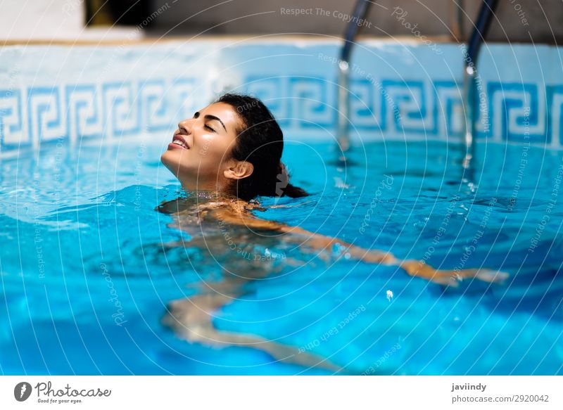 Schöne gebräunte Frau im Bikini, die sich im Schwimmbad entspannt. Lifestyle Glück schön Körper Haare & Frisuren Haut Erholung Freizeit & Hobby