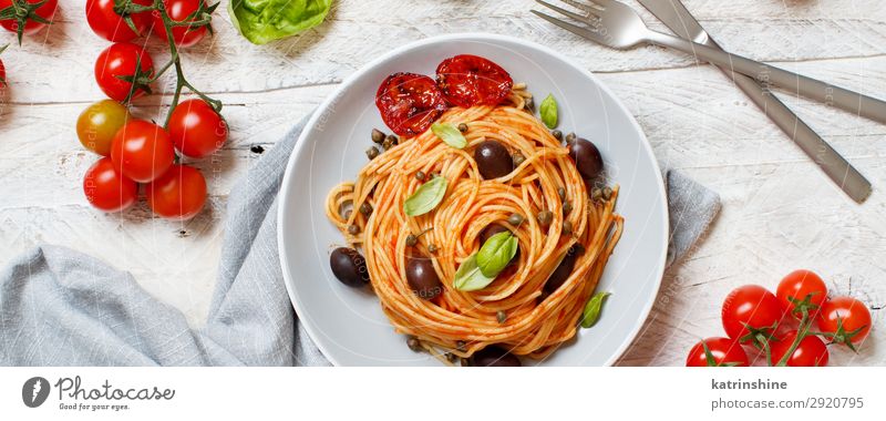Spaghetti mit Tomatensoße, Oliven und Kapern Gemüse Mittagessen Abendessen Vegetarische Ernährung Teller Gabel Löffel Holz oben grün rot Tradition Spätzle