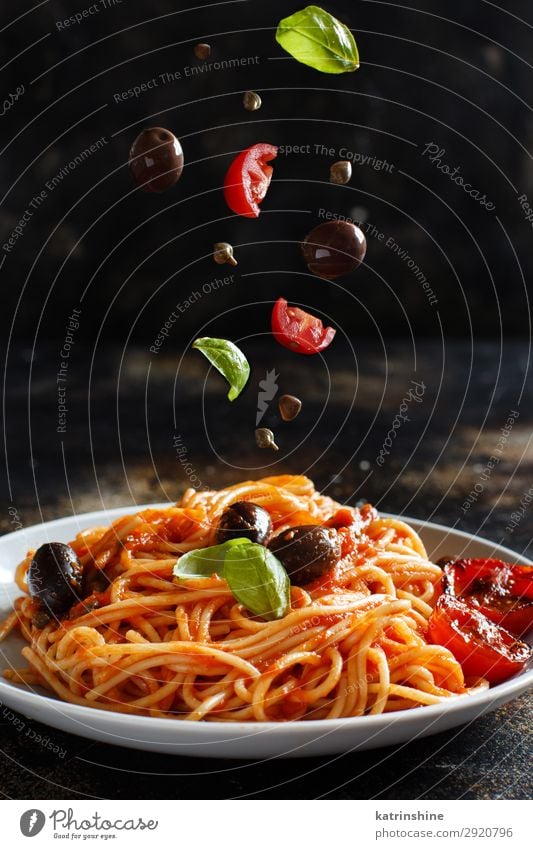 Spaghetti mit Tomatensoße, Oliven und Kapern Gemüse Mittagessen Abendessen Vegetarische Ernährung Teller Holz grün rot Tradition Spätzle puttanesca Kapriolen