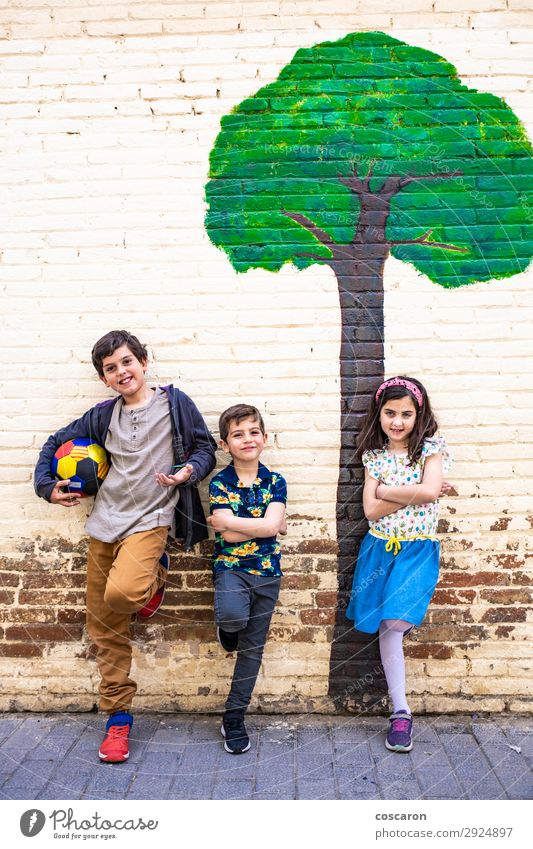 Porträt von drei Kindern mit gemaltem Baumhintergrund Lifestyle Freude Glück schön Spielen Sommer Sport Fußball Ball Schule Schulhof maskulin feminin Kleinkind