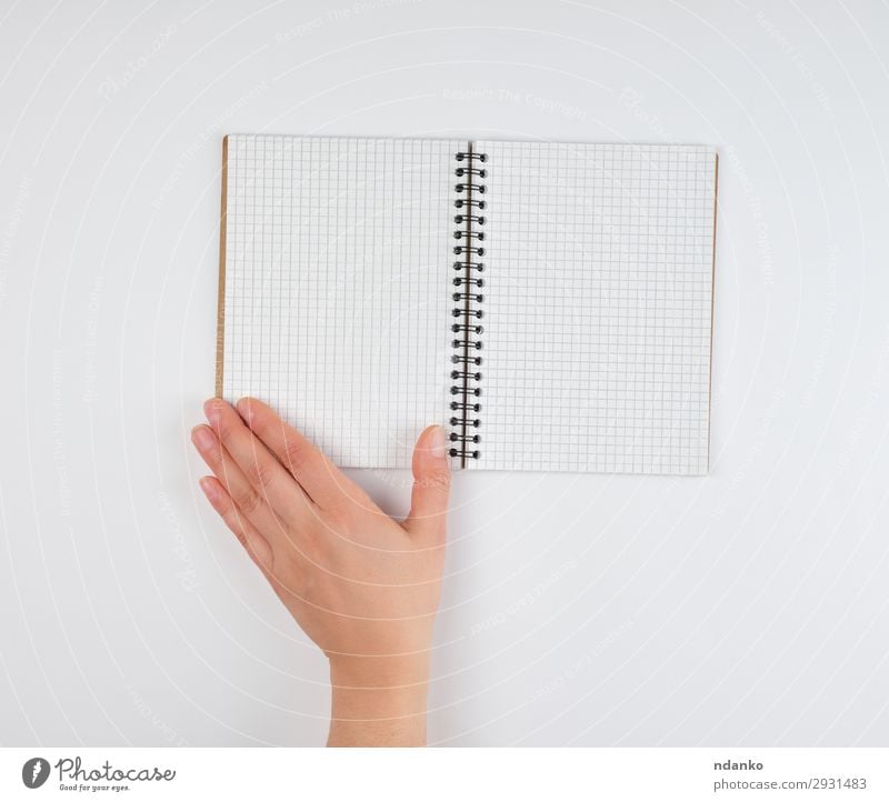 leeres offenes Notizbuch in einer Zelle und einer weiblichen Hand Schule lernen Büro Business Mensch Frau Erwachsene Arme Finger Buch Papier schreiben weiß