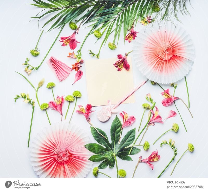 Leere Grußkarte mit Papier-Partyfächern, tropischen Blättern und exotischen Blumen auf weißem Hintergrund, Ansicht von oben. Flacher Schlag. Rahmen. Kopierraum für Ihren Text oder Ihr Design
