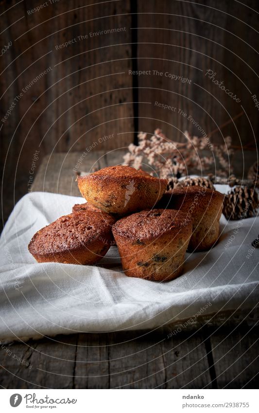 gebackene kleine runde Muffins auf einer weißen Stoffserviette Frucht Brot Dessert Tisch Holz frisch retro braun Tradition Bäckerei Holzplatte Kuchen