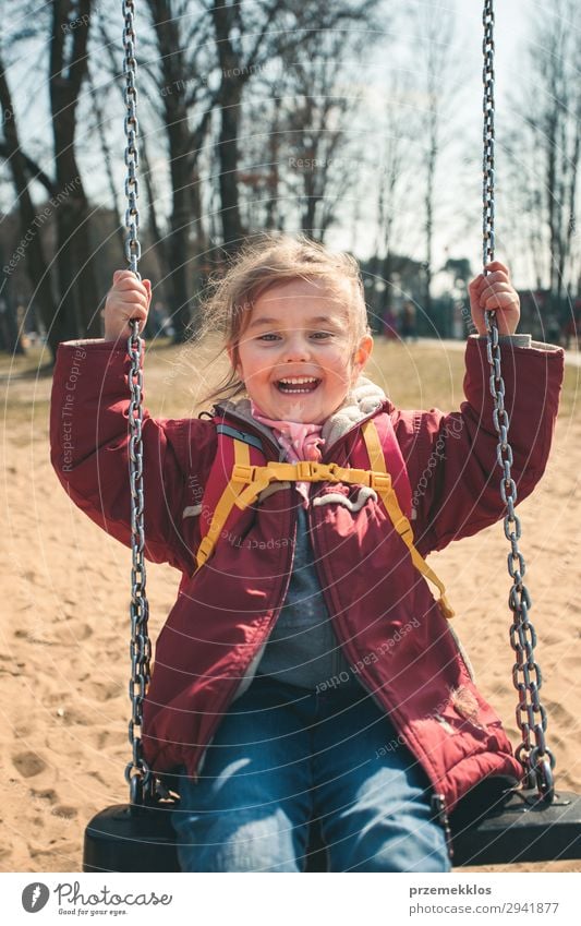 Kleines lächelndes Mädchen, das an einem sonnigen Frühlingstag in einem Park schwingt. Lifestyle Freude Glück schön Spielen Sommer Kind Frau Erwachsene Kindheit