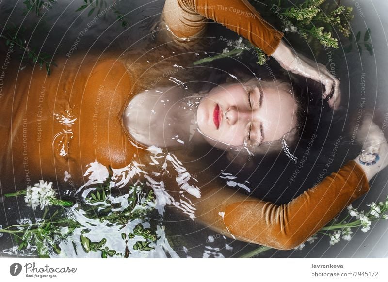 Frau, die in der Badewanne liegt und mit Holzkohlewasser gefüllt ist. Septum Schwimmen & Baden Beautyfotografie Körper Bombe Ast Körperpflege Kaukasier Entzug
