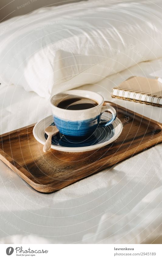 Kaffee auf Holztablett mit Notizbuch und Stift auf dem Bett Hintergrund Schlafzimmer Getränk Frühstück braun Tasse heiß Morgen Becher Papier Schreibstift