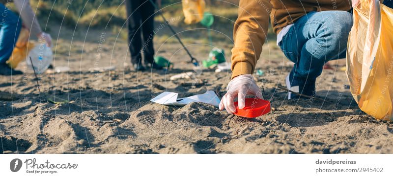 Junger Mann putzt den Strand Arbeit & Erwerbstätigkeit Internet Mensch Erwachsene Familie & Verwandtschaft Hand Menschengruppe Umwelt Sand Kunststoff dreckig