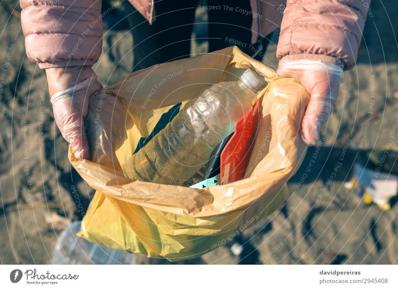 Frau, die den vom Strand gesammelten Müll zeigt. Kind Arbeit & Erwerbstätigkeit Mensch Erwachsene Hand Umwelt Sand Kunststoff dreckig Teamwork zeigen Müllsäcke