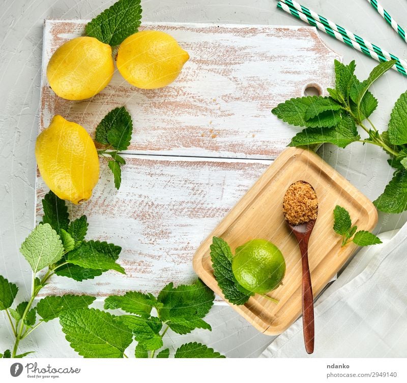 ganze Zitronen und Limetten, brauner Zucker Frucht Kräuter & Gewürze Limonade Saft Löffel Tisch Blatt Tube Holz frisch oben saftig gelb grün weiß Haufen