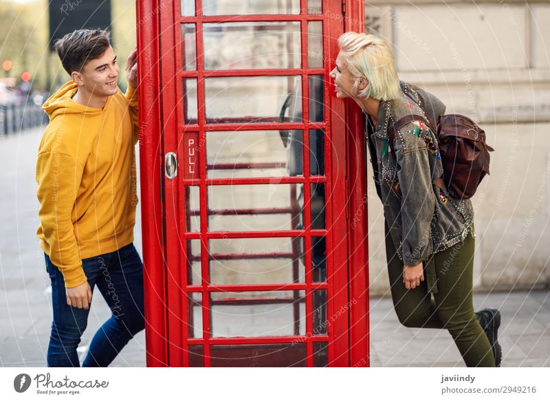 Junge Freunde in der Nähe einer klassischen britischen roten Telefonzelle. Lifestyle Ferien & Urlaub & Reisen Tourismus Sightseeing Mensch maskulin feminin