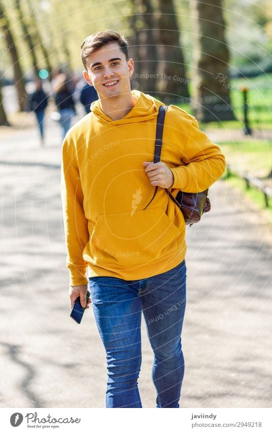 Junger Mann mit Smartphone auf der Straße in einem Stadtpark Lifestyle Glück Ferien & Urlaub & Reisen Telefon PDA Technik & Technologie Mensch maskulin