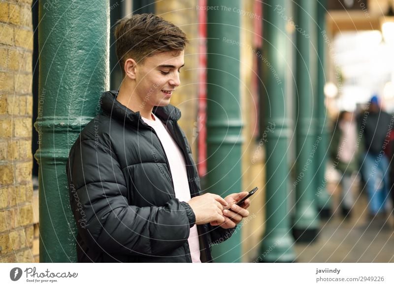 Junger Stadtmensch mit Smartphone im urbanen Hintergrund. Lifestyle Stil Glück Telefon PDA Technik & Technologie Mensch maskulin Junger Mann Jugendliche