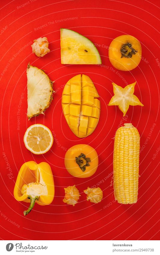 verschiedene gelbe und orange Früchte und Gemüse auf rot Mango Frucht flach legen Paprika Klingel Corny Zitrone Zitrusfrüchte frisch Gesundheit