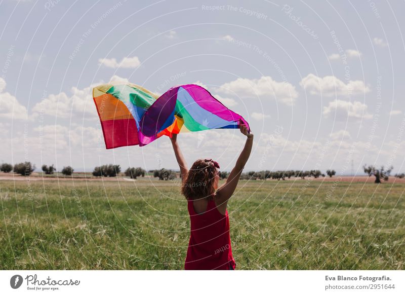 Frau hält die Gay Rainbow Flag auf einer grünen Wiese im Freien. Lifestyle Freude Glück Freizeit & Hobby Freiheit Sommer Sonne Hochzeit Mensch feminin