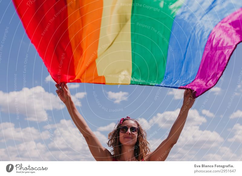 Frau hält die Gay Rainbow Flag über dem blauen Himmel im Freien. Lifestyle Freude Glück Freizeit & Hobby Freiheit Sommer Sonne Hochzeit Mensch Homosexualität