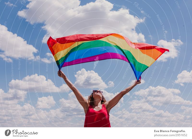 Frau hält die Gay Rainbow Flag über dem blauen Himmel. Lifestyle Freude Glück Freizeit & Hobby Freiheit Sommer Sonne Hochzeit Mensch feminin Homosexualität