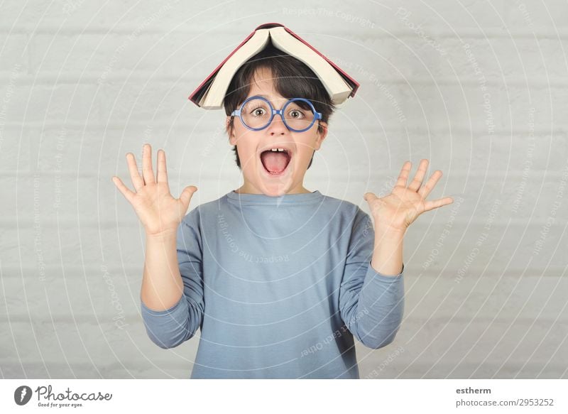 fröhliches und lächelndes Kind mit Buch auf dem Kopf Lifestyle Freude Spielen lesen Bildung Schule Schulkind Schüler Mensch maskulin Kleinkind Kindheit 1