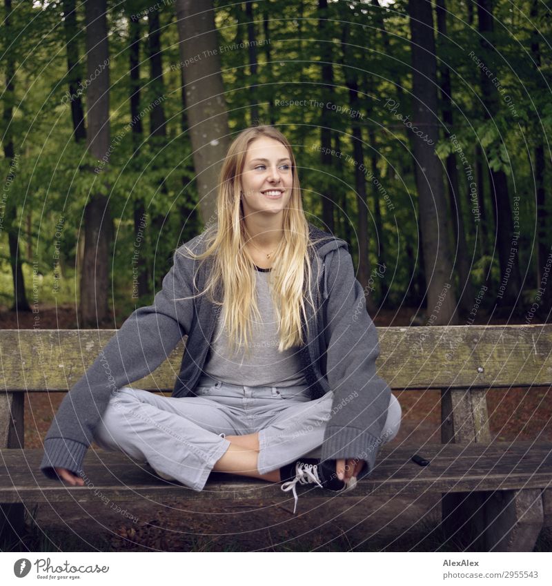 Blondes Mädchen sitzt auf einer Bank im Wald Freude schön Wellness Leben Freizeit & Hobby Junge Frau Jugendliche 18-30 Jahre Erwachsene Umwelt Natur Frühling
