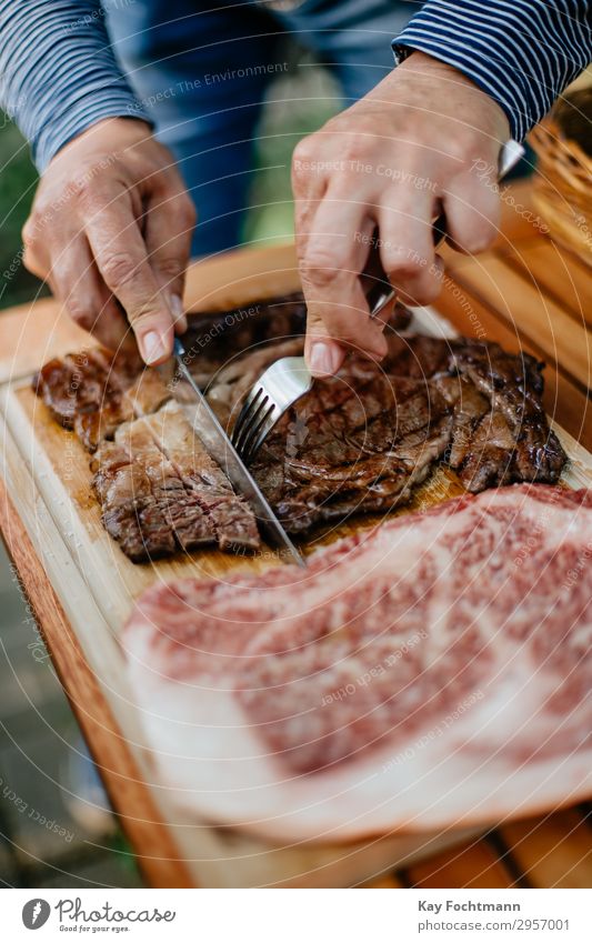 Hände eines Mannes, der gegrilltes Kobe-Rindfleisch in Scheiben schneidet Barbecue grillen Beefsteak Küche kulinarisch geschnitten Schneiden Feinwäsche