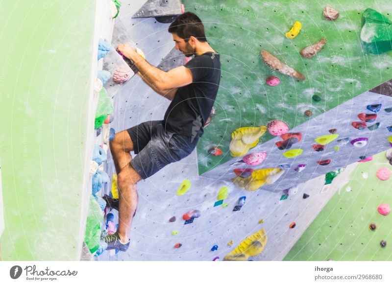Mann übt Klettern an einer künstlichen Wand in Innenräumen. Lifestyle Freude Freizeit & Hobby Sport Bergsteigen maskulin Junger Mann Jugendliche Erwachsene 1