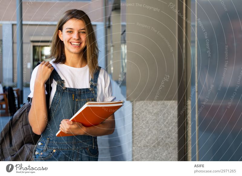 Lächelndes Schülermädchen am Schuleingang Lifestyle Glück schön Studium Frau Erwachsene Jugendliche brünett lachen stehen niedlich Teenager Mädchen Kaukasier