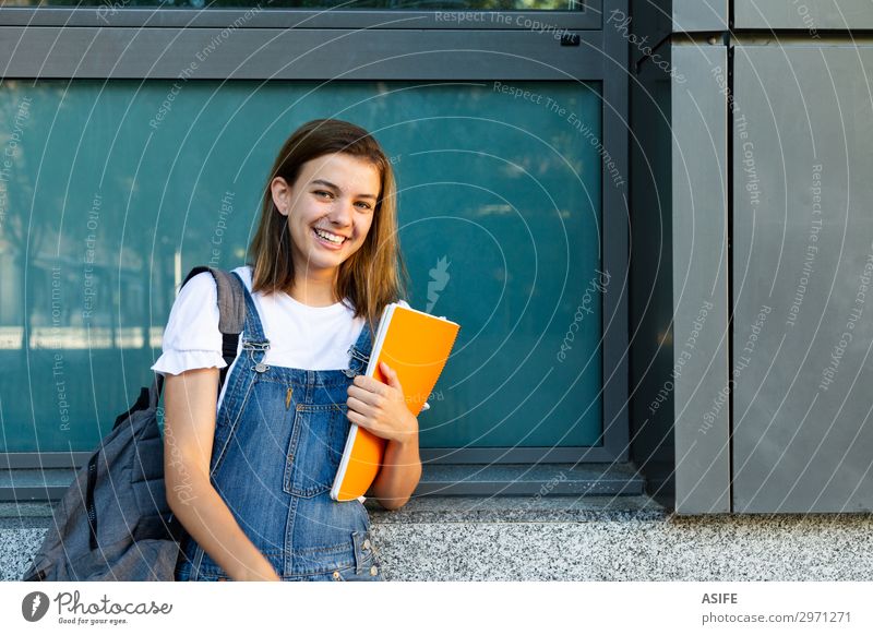 Porträt einer glücklichen Schülerin, die sich an das Fenster der Schule lehnt Lifestyle Glück schön Studium Frau Erwachsene Jugendliche brünett Lächeln lachen