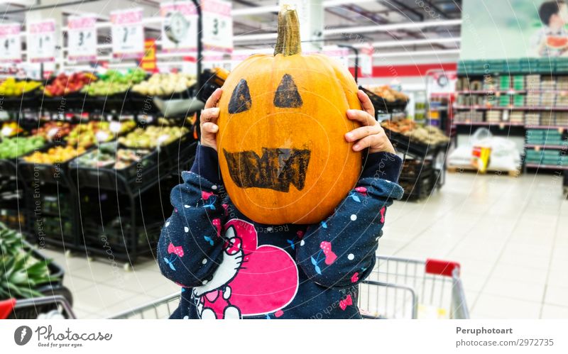 Kleines Mädchen hält einen Kürbis in den Händen, an Halloween. Gemüse Freude Glück Dekoration & Verzierung Feste & Feiern Kind Mensch Frau Erwachsene Kindheit