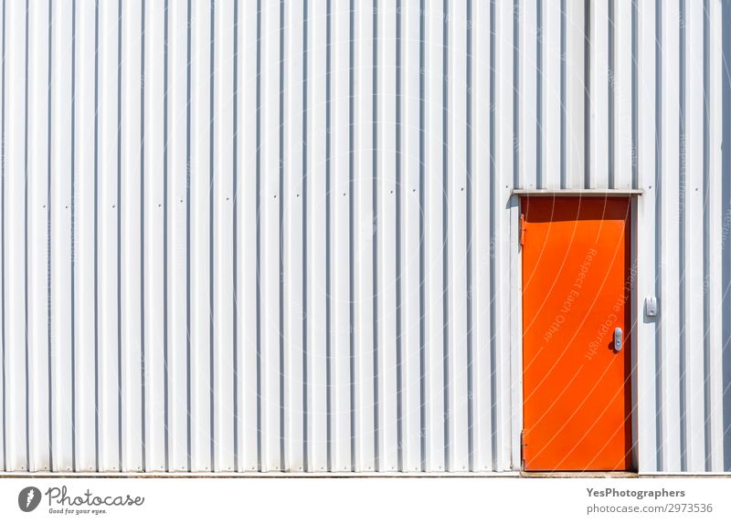 Orangefarbene Metalltür und eine weiße Hallenwand Fabrik Industrie Business Gebäude Architektur Fassade Stahl modern Zugang Leichtmetall Hintergrund zugeklappt